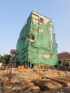 Bamboo scaffolding around the exterior of a five story apartment building that is under construction in Southeast Asia.