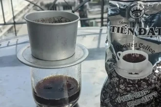 A bag of coffee beans, and brewing a cup of coffee using a Vietnamese phin filter.