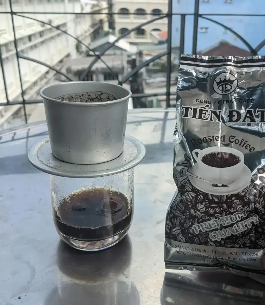A bag of coffee beans, and brewing a cup of coffee using a Vietnamese phin filter.
