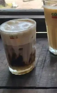 An image of a coffee on a table in a café in Vietnam called Cong Cafe. The coffee is: Café (coffee) Bac Xiu.