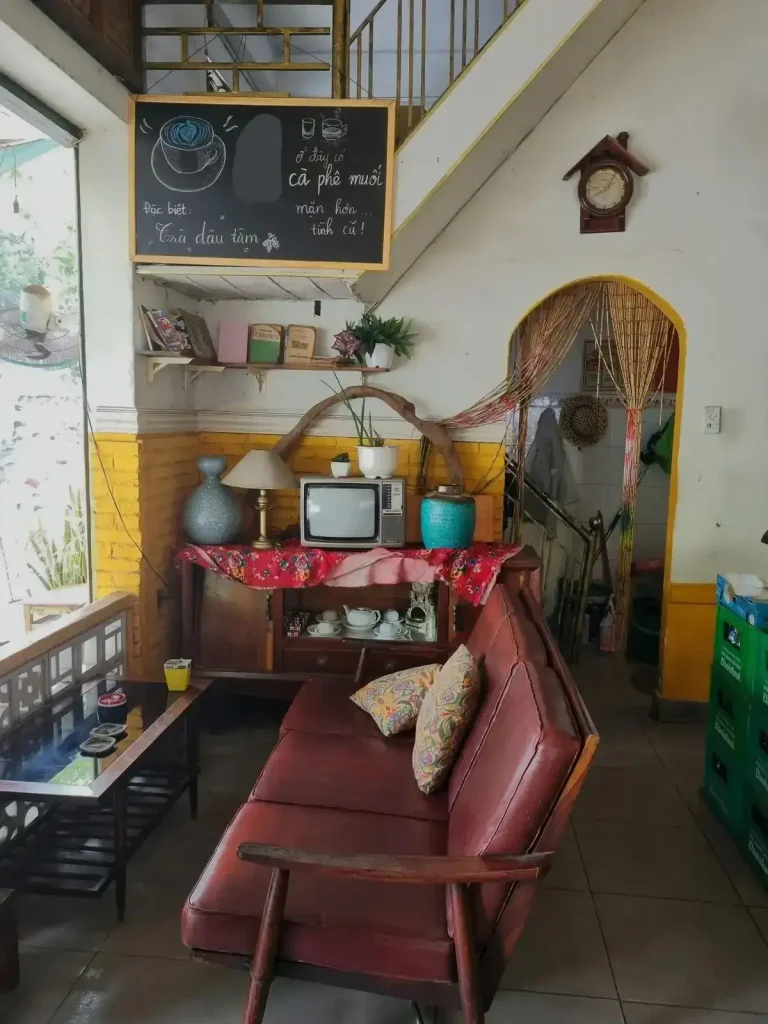 Inside of a café in Vietnam with a couch and table that looks outside.