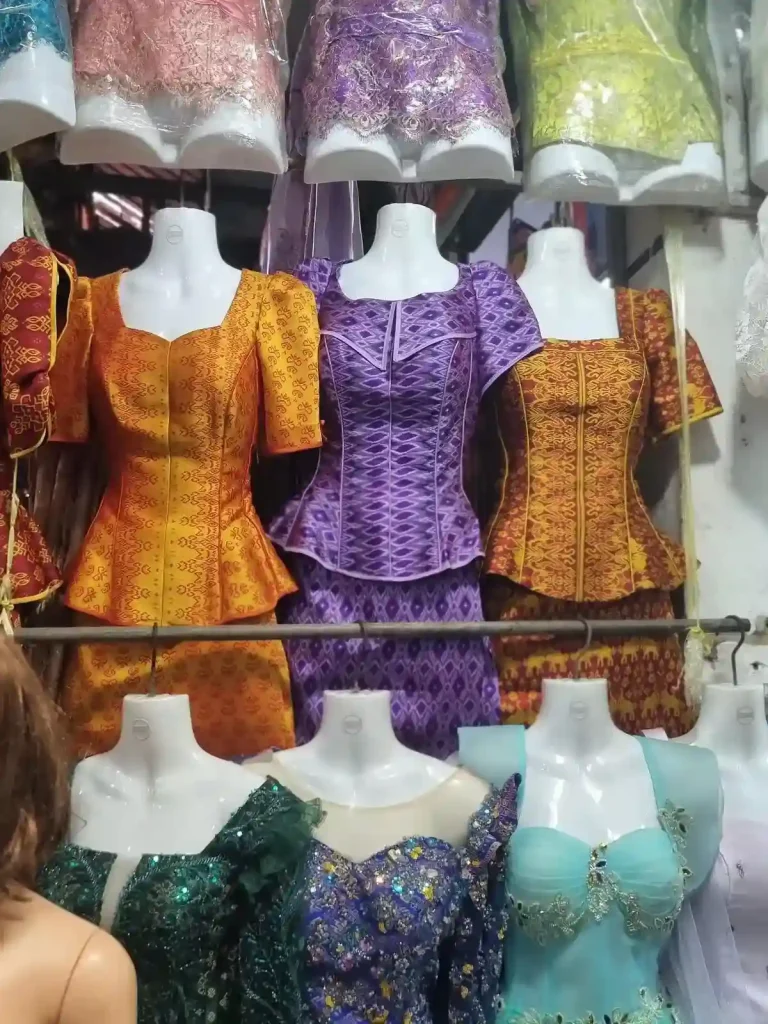 A display of formal Cambodian women's dresses with various patterns and colors.
