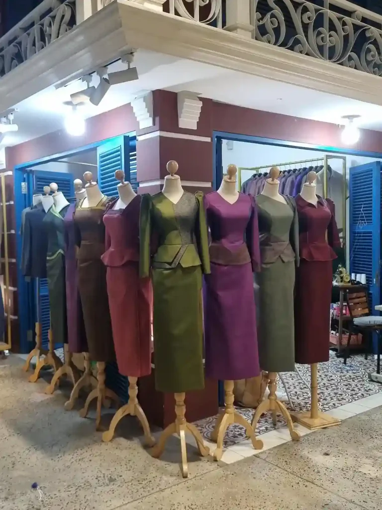 Several formal Cambodian-style women's dresses, all of which are solid color. All are the same design, but with different colors.