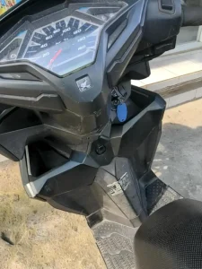 Storage compartments built into the dashboard on a Honda Click automatic motorbike.