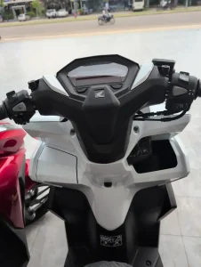 Storage compartments built into the dashboard on a Honda Click automatic motorbike.