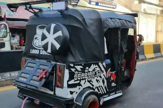 A Bajaj Indian-style tuk-tuk in Cambodia. It is three wheeled and is fully enclosed. This tuk-tuk is decorated with various visual graphics per the owner/driver's amusement, which is a common thing to do in Cambodia.