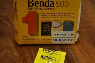 An image of a one-pill box of Mebendazole, along with the pill taken out of the box. This is a medicinal pill to treat for parasitic worm infections. In Southeast Asia, it is commonly taken to ensure that the body stays clear of parasitic worms.