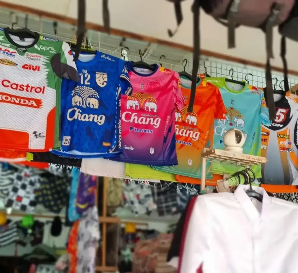 An assortment of dry-fit t-shirts or jerseys at store in Thailand. Some shirts have the chang beverage company logo on them, which is well known for producing Change beer.