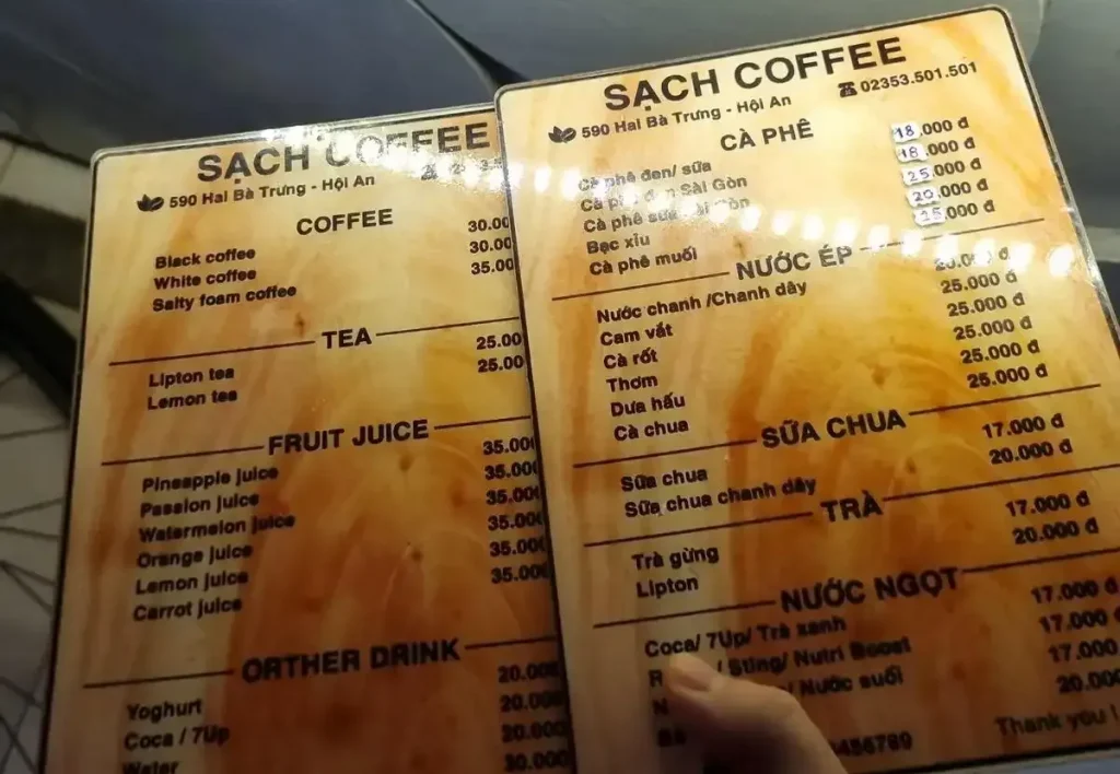 Two menus at a café in Vietnam, one for locals (written in Vietnamese) and one for foreigners (written in English). The menus have different pricing, where the foreigner menu pays more. The foreigner menu costs thirty thousand Viet Dong for a "Black coffee", while it's Vietnamese-written counterpart "Ca phe den" (coffee black) costs eighteen thousand Viet Dong. That is a forty percent increase for being foreign. A can of Coca Cola is twenty thousand for foreigners versus seventeen thousand for locals.