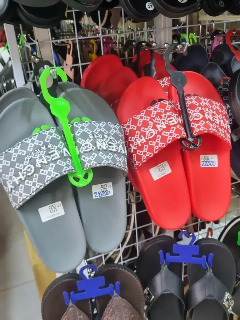 Fake Givenchy branded men's sandals in grey and red color for approximately five dollars and fifty cents in Cambodia.