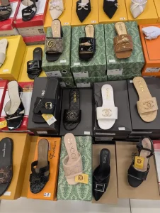 Many womens shoes on display at a department store in Southeast Asia. The shoes a fake Channel, Gucci, and Luis Vuitton branded.
