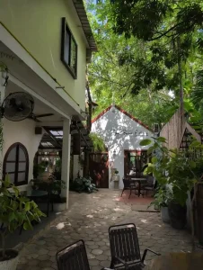 A very shady section of a fancy café in Southeast Asia with outdoor seating.