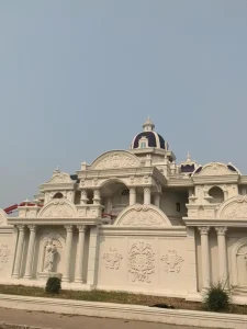 A very fancy mansion house in Laos. This house has elaborate decorations. It also has a concrete wall around it with roman pillars and statues built into the wall.