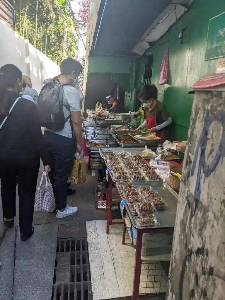 A food stall setup to take advantage of the high foot traffic at an exit stop of a water bus station in Bangkok. The walkway is narrow.