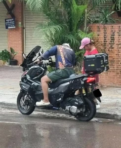 A Honda ADV 160cc automatic motorbike in Southeast Asia. The rider is parked along the road.