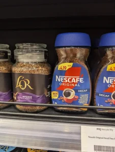 A container of Nescafe-branded instant coffee for sale at a grocery store. The total weight is ninety-five grams.