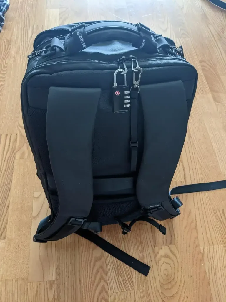This is a rear view of the Mark Ryden branded 30 liter backpack with 3 main compartments. Attached is a TSA 4-pin travel lock metal to lock the zippers.