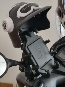 A cellphone holder mounted on the handlebar of a motorbike in Southeast Asia.