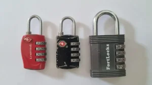 Multiple four-pin combination travel locks, all with metal shackle (locks are also sold that have a cable shackle). Two locks are "regular" size, and one lock is large size, in which it is larger in dimension and has a thicker metal shackle. These locks are TSA approved.
