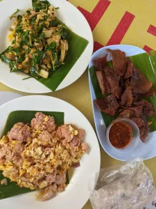 Three plates of northern Thai dishes. One is a meat jerky with dipping sauce.