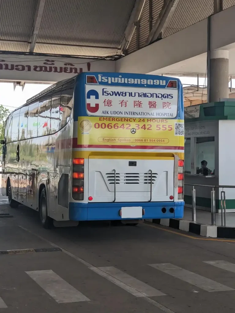 A full-sized passenger bus crossing the Thailand - Laos land border. This immigration border is where passengers exit one country (exit stamp) and enter another country (entry visa or stamp).