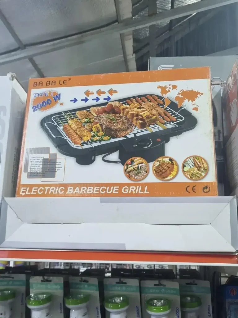 A portable electric barbecue grill for sale at a store in Southeast Asia. The grill is two thousand Watts (i.e. two kilo Watts). It does not have a cover - it's open-air. It has an on/off temperature setting, adjusted by twisting a switch. It also has a grill plate made of wire in which juice can drip through (not a solid plate like sheet metal). The grill plate has metal handles on each end to lift it off the grill, but be carefull as metal handles might get hot.