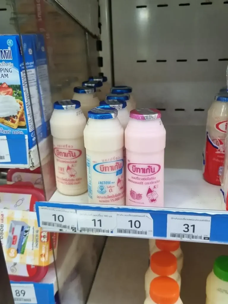 A small bottle of probiotic drink on a convenience store shelf in Thailand priced at roughly thirty-five US cents (ten Thai baht). Flavors shown are regular and strawberry. This is good to drink when you have an upset stomach or diarrhea.