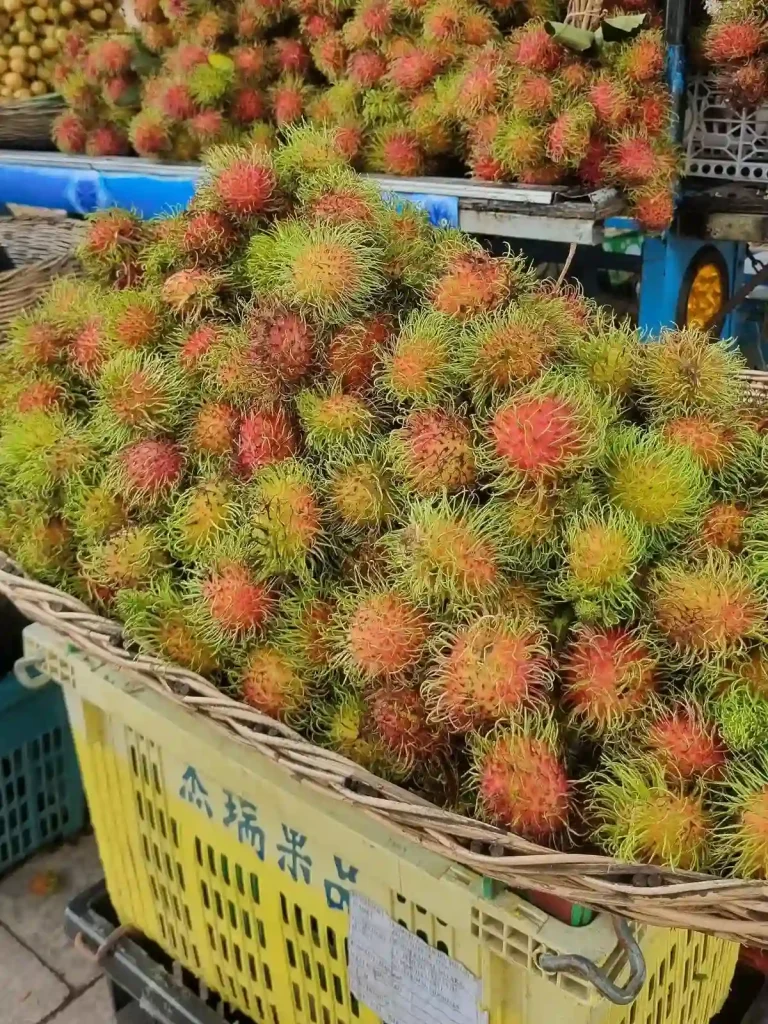 Rambutan fruit in whicker baskets on display for sale in Southeast Asia.