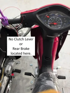 An image of a semi-automatic motorbike. There is text with arrows pointing at the controls of a semi-automatic motorbike. This image highlights the lack of a clutch lever on the handlebar's left-hand side, where it would be located on a manual motorbike. It also lacks a rear brake lever at this location (handlebar left-hand side), where it would be located on an automatic motorbike.
