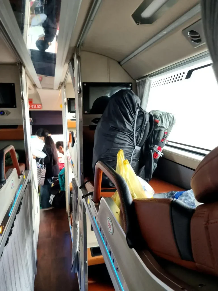 Sleeper bus in Vietnam that is 3 beds wide. The center bed has 2 rows on each side. The bus width is bed, row, bed, row, bed.