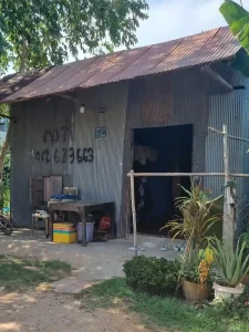 A small shack that someone lives in, with corrugated stell sheet for the walls and roof. The skeleton frame of the house appears to be wood.