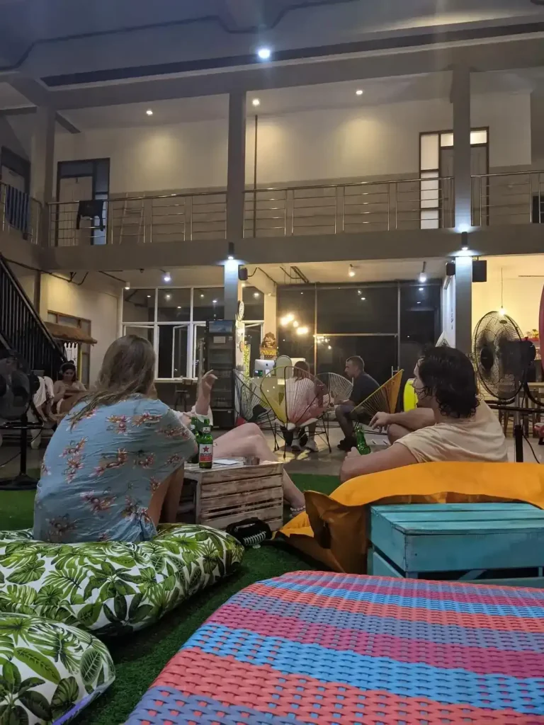Guests socializing in a hostel common area in Bali, Indonesia. Some are sitting around drinking Bintang beer.