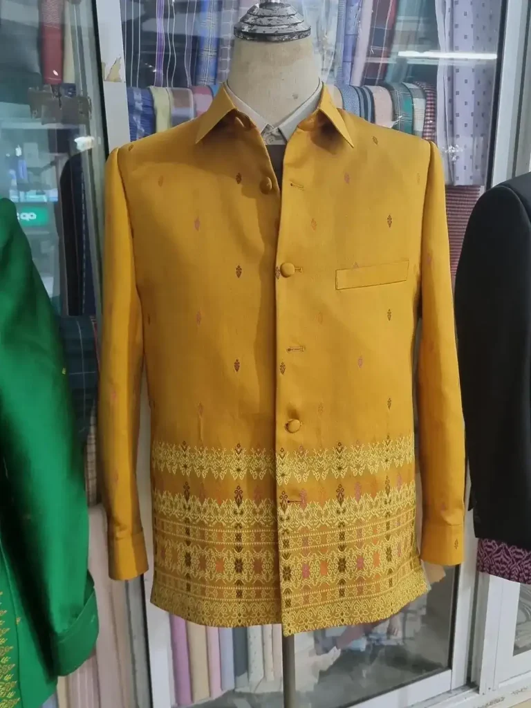 A formal Cambodian-style long-sleeve men's shirt of yellow color and pattern imprints on a mannequin.