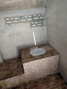 A squat toilet in Southeast Asia. This is a porcelain toilet that is essentially a hole in the ground.