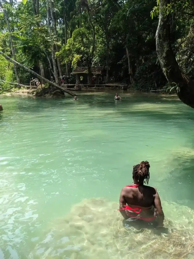 People swimming in a jungle lagoon in Laos.