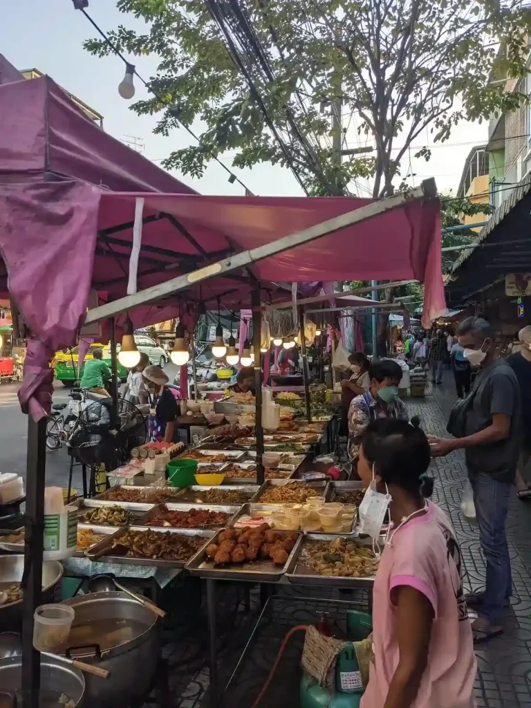 Thai street food stall with canopy. About twenty different dishes are on display to take to-go in Thailand.