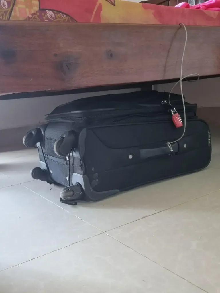 Luggage tethered to an anchor object while traveling using a metal braided travel cable and TSA travel lock.