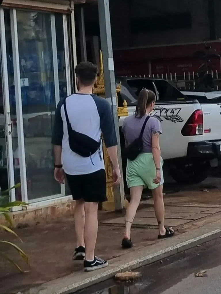 Travelers walking down the street wearing a fanny pack (a.k.a. waste pack) around their shoulders in Southeast Asia.