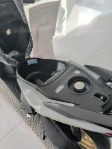 Under seat storage compartment on a Honda Click automatic motorbike. The gas tank lid is located under the seat, too.