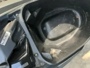 Under seat storage compartment on a Honda Wave semi-automatic motorbike. The gas tank lid (not shown) is located under the seat, too.