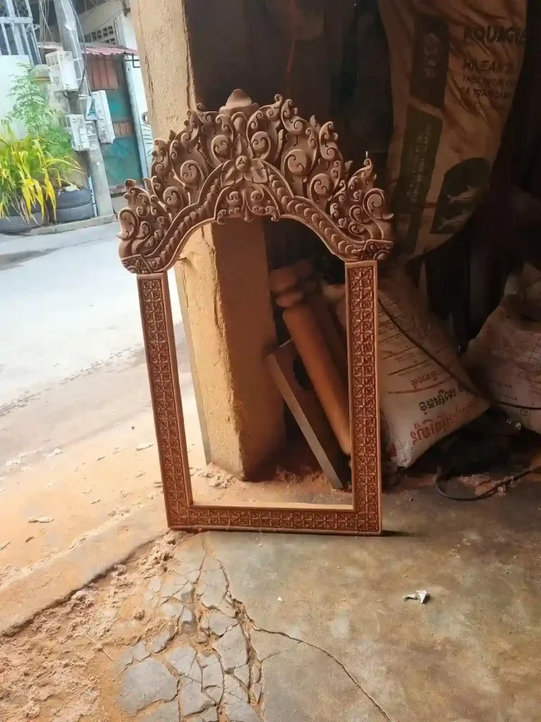 A wooden frame for a picture or mirror with very detailed carvings from Cambodia. The carvings are describes as a distinct Cambodian style.
