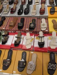 Many womens shoes on display at a department store in Southeast Asia. The shoes a fake Channel, Gucci, and Luis Vuitton branded.