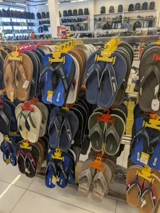 Flip flops of various color on a rack, for sale in a store in Southeast Asia.