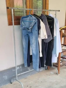 Hang drying laundry at a rental in Southeast Asia. A metal clothes rack is provided to hand cloths on. This rack can be used to dry clothes outside, or to store/hang clothes inside the rental.