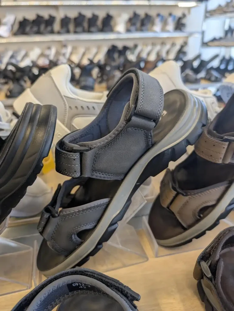 A pair of hiking sandals that have a backstrap that wraps around the rear of the foot to hold the sandal on.