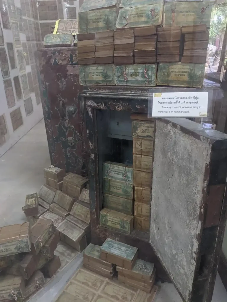 Stacks of world war two era Japanese cash within and surrounding a safe at the hellfire pass museum in Kanchanaburi, Thailand. The case is old and moldy, but decently well preserved.