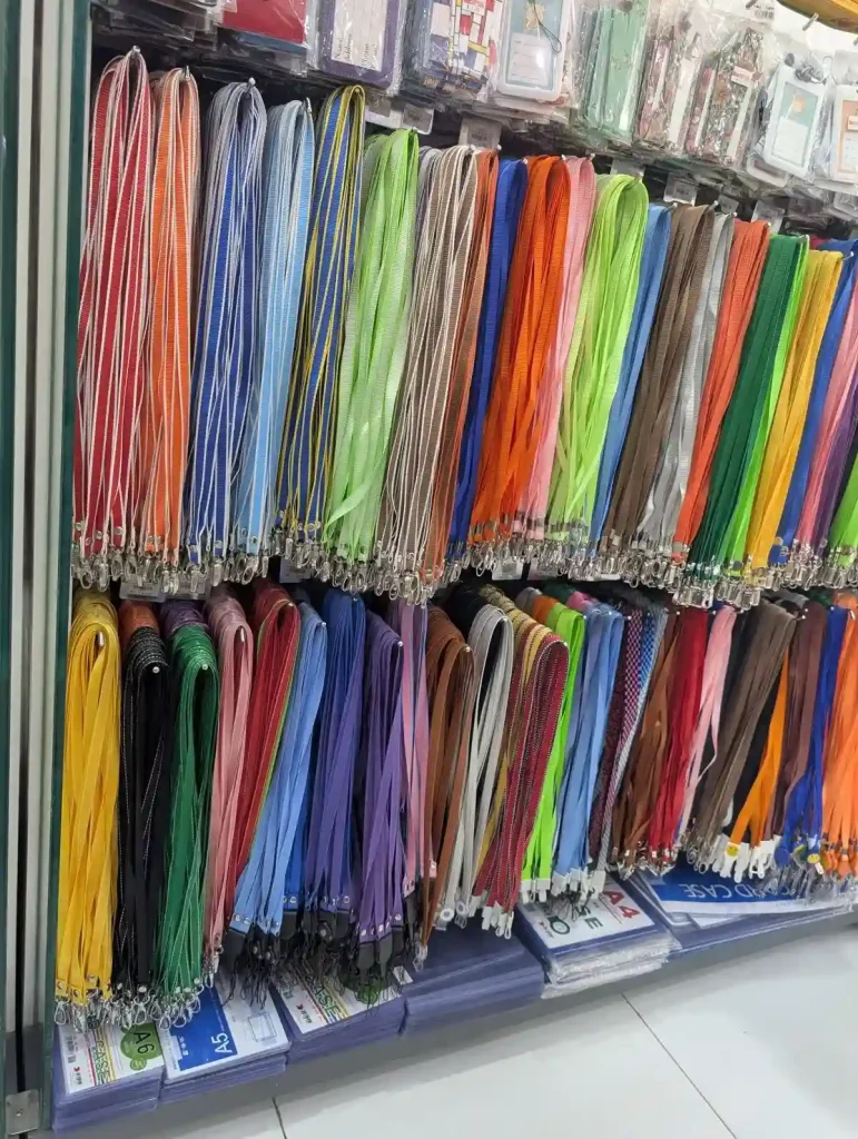 A section within an isle at a bookstore with lanyards for sale. The lanyards are all the same, but are of various different colors.
