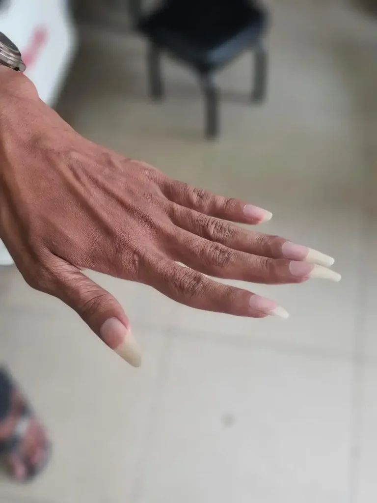 A male Vietnamese person's hand with long finger nails.