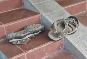 A pair of Merrell hiking shoe sandals on a small flight of stairs. This pair is a hybrid type between a shoe and sandal.
