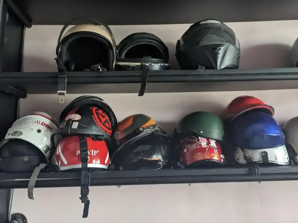 Motorcycle helmets on a rack at a motorbike (scooter) rental shop in Southeast Asia.